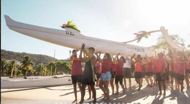Turma da Hale Hoe levantando a canoa Vó Bia na areia